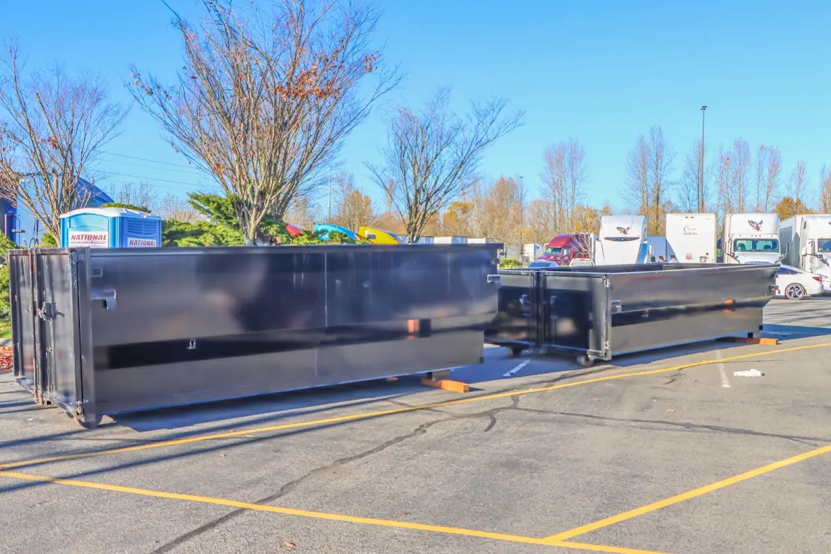 Professional dumpster rental service with roll-off container on residential driveway in Topsfield